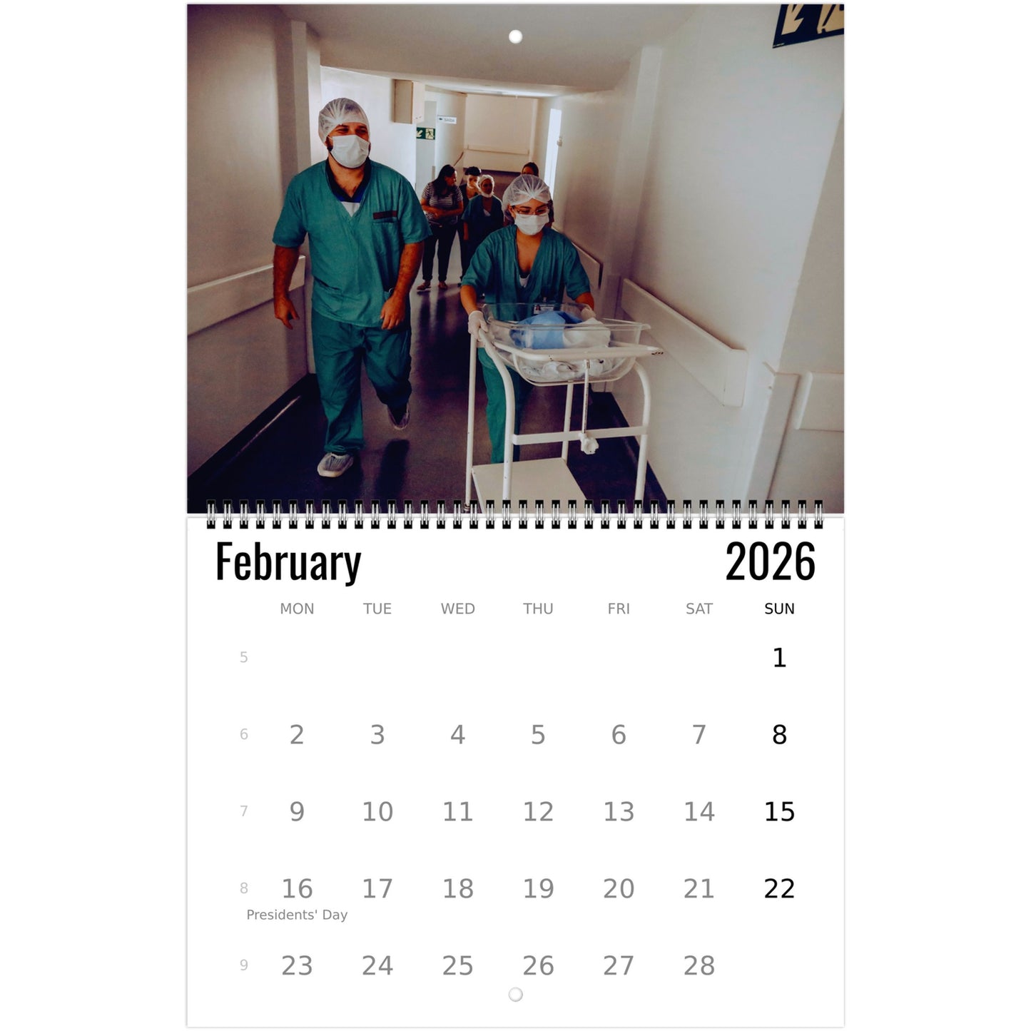 Calendar page for February 2026 showing a photograph of healthcare workers in a hospital setting.